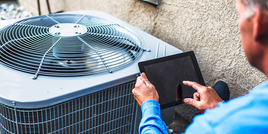 Homeowner inspecting air conditioner for issues