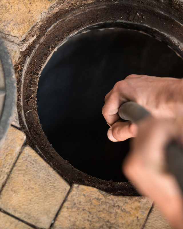 Triangle Contractors commercial plumber water jet clearing a drain clog.