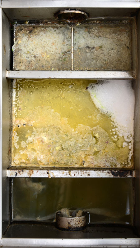Grease trap shown before cleaned and drained by Triangle Contractors.